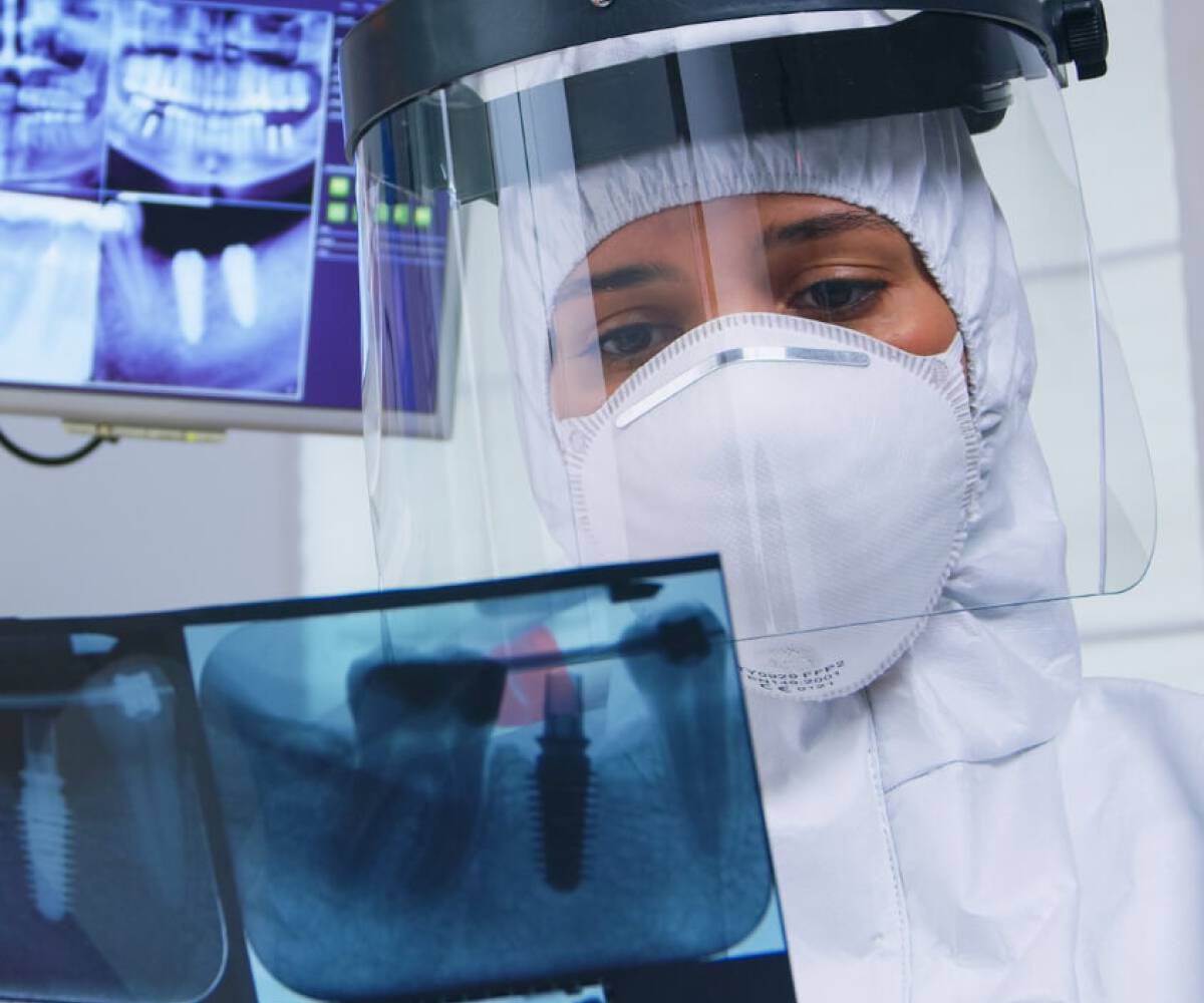 diş doktoru hastasını dental görüntülenme raporunu inceliyor