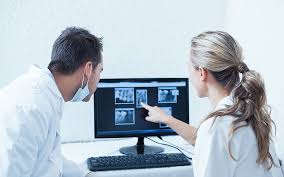 İki diş doktoru hastalarının yapay zeka radyoloji tespitlerini incelemektedir